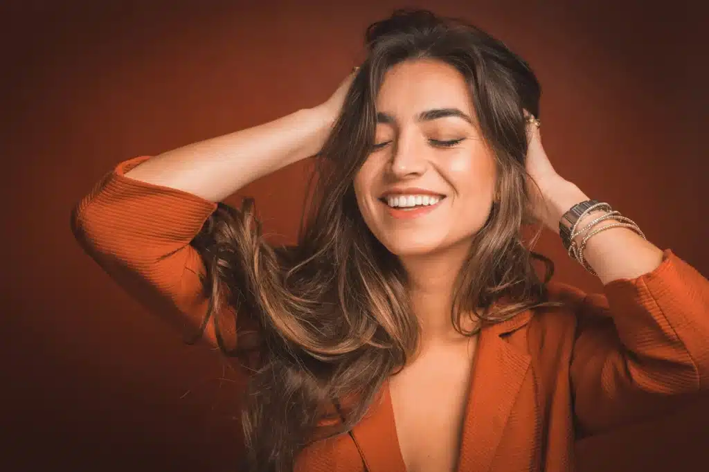 Woman touching hair after recieving a Keratin Treatment in London